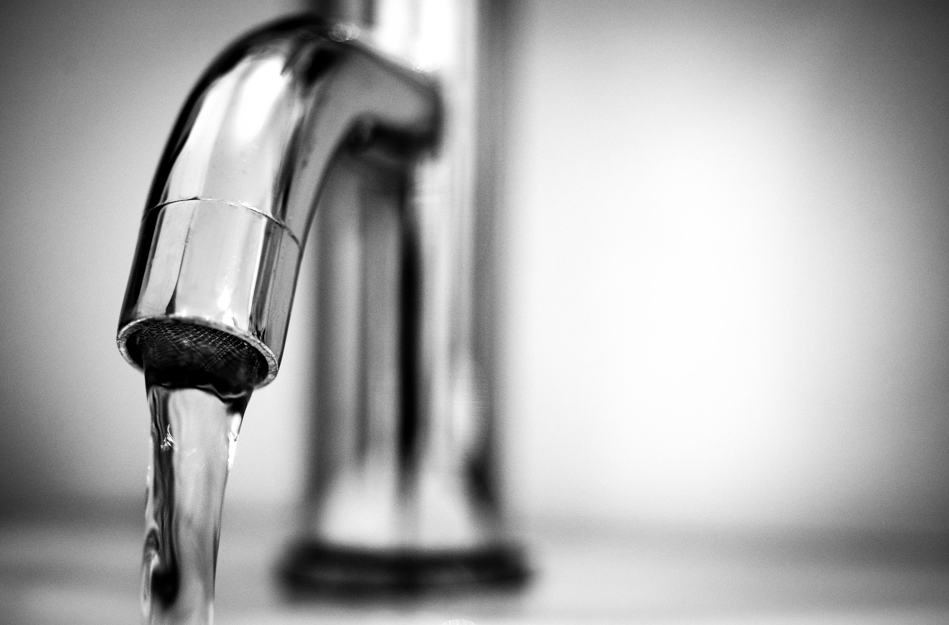 A sink tap with running water.